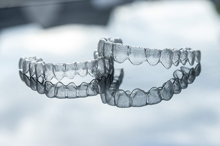Schienentherapie für schiefe Zähne. Transparente Zahnschienen von Invisalign®.