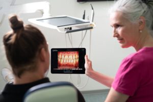 Dr. Kinner zeigt einem Patienten einen Scan seiner Zähne